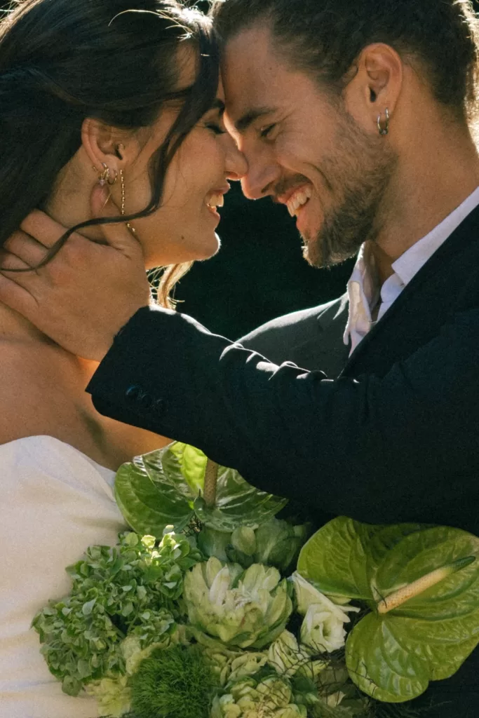 Close-up of the couple sharing an intimate moment surrounded by greenery at Finca Es Convent.