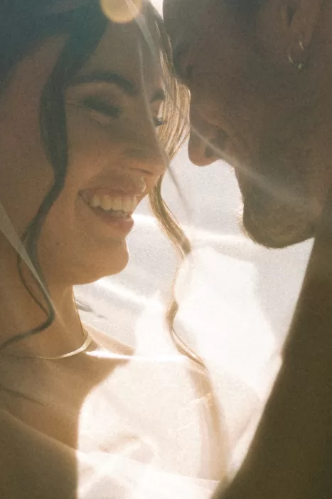 Sunlit close-up of the couple smiling beneath the bride’s veil during golden hour at Finca Es Convent.