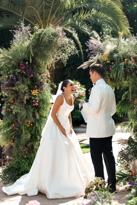 Couple exchanging vows beneath a floral arch during an outdoor ceremony at Finca La Concepción.