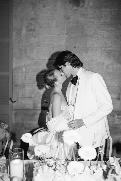 Black and white evening moment of the bride and groom kissing at Fontsanta during the wedding reception.