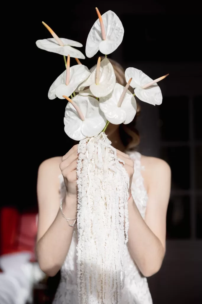 Close-up of the bride holding a sculptural white anthurium bouquet during her wedding at Grand Hotel du Lac.