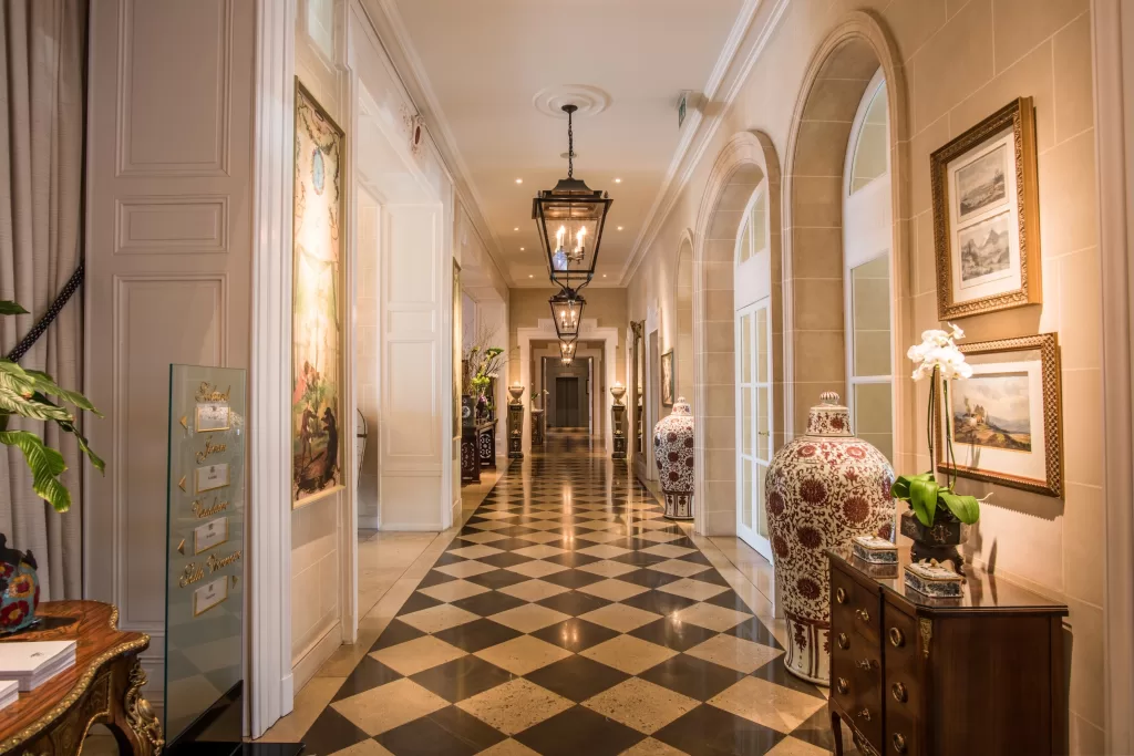 Ornate hallway at Grand Hotel du Lac with patterned marble floors, lantern lighting and classic decorative details.