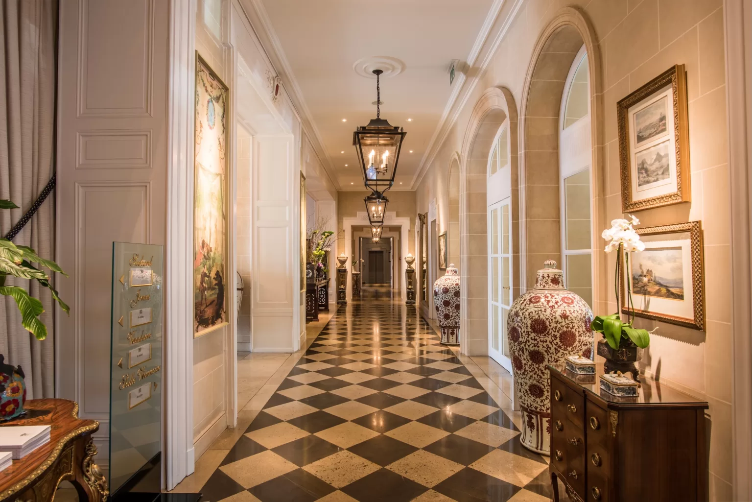 Ornate hallway at Grand Hotel du Lac with patterned marble floors, lantern lighting and classic decorative details.