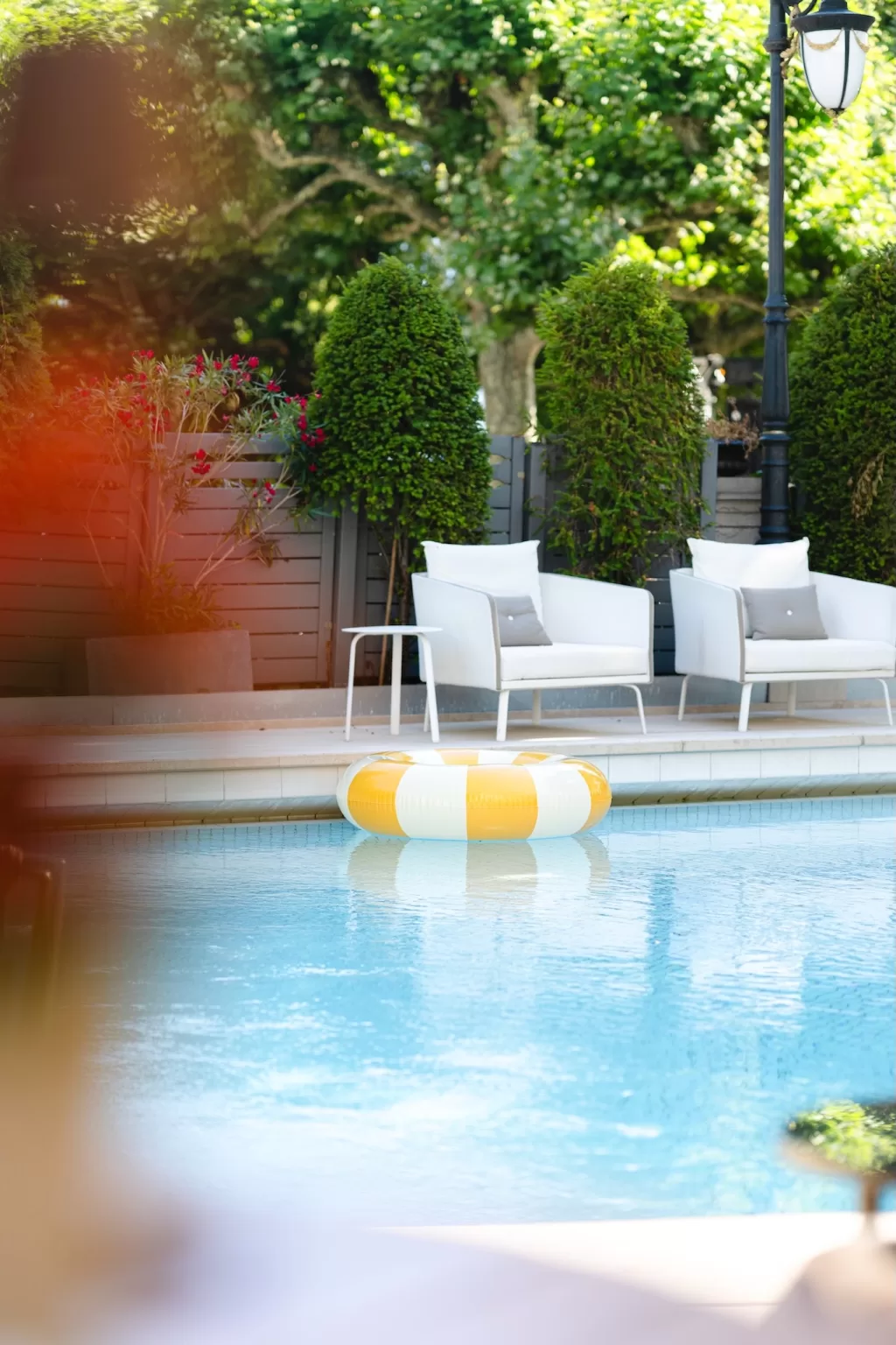 Grand Hotel du Lac exterior with swimming pool and classic Belle Époque façade on a bright summer day.