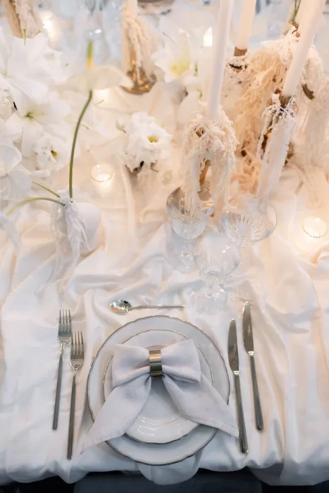 Elegant wedding table setting at Grand Hotel du Lac with soft white linens, sculptural florals and refined glassware.