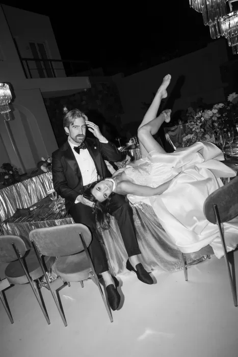 Bride and groom relaxing at an elegant black-tie wedding reception at Islet Santorini, styled with dramatic lighting and modern table design.