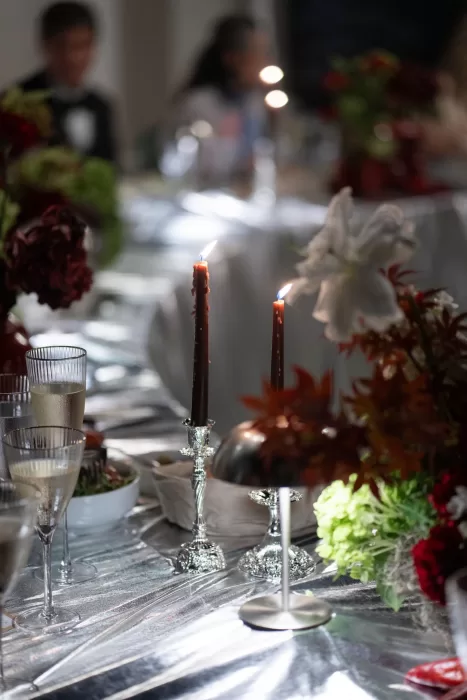 Candlelit wedding table detail with reflective linens and florals at an evening reception at Islet Santorini.