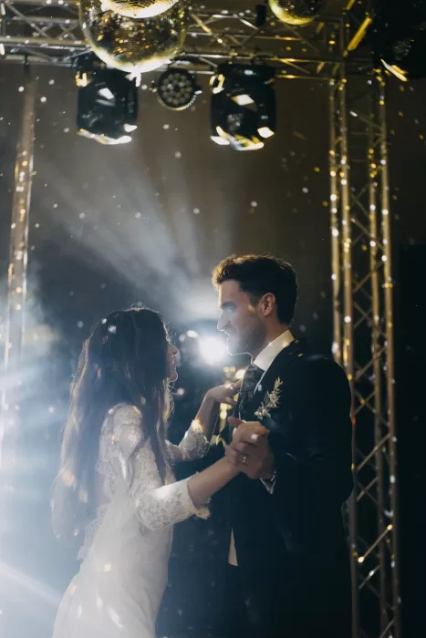 First dance moment under disco balls and warm lighting during the evening celebration at Mas de Les Voltes.