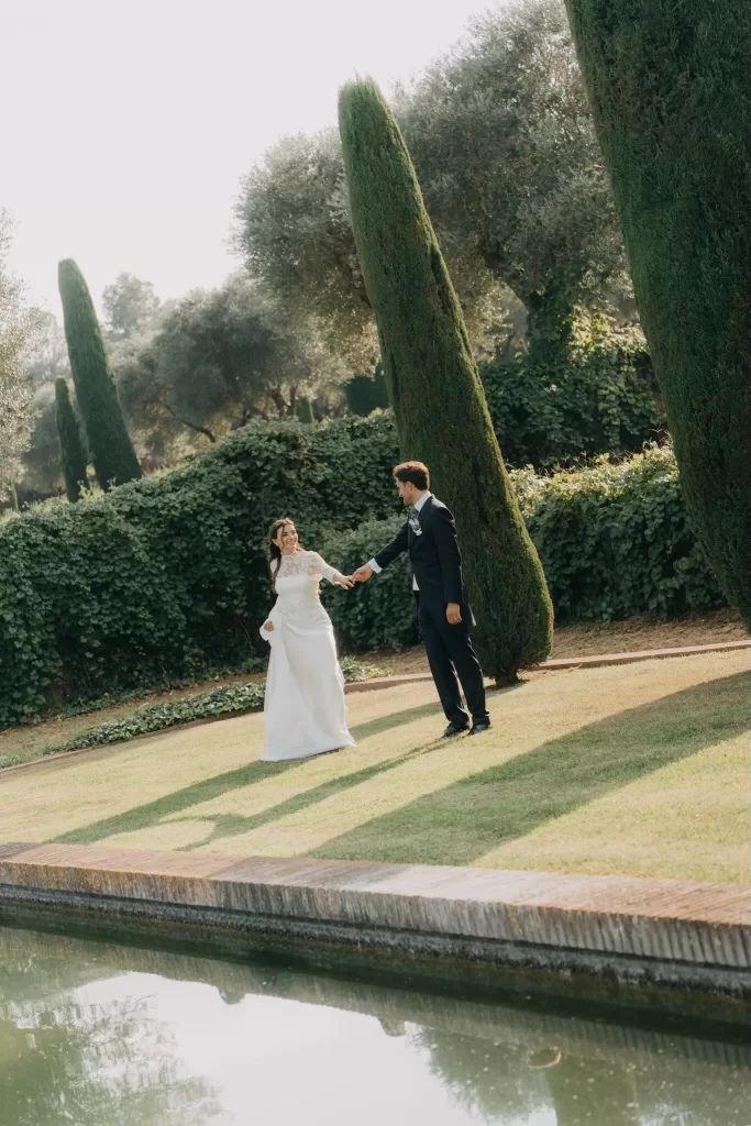 Playful moment between the couple by the water’s edge in the manicured gardens of Mas de Les Voltes.