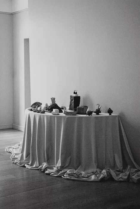 Minimalist still life of a wedding reception table with food, textures, and soft draping, styled in a modern editorial aesthetic.