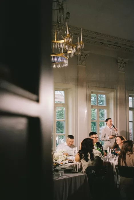 Wedding guest giving a speech during an intimate candlelit reception, photographed with a documentary yet editorial approach.
