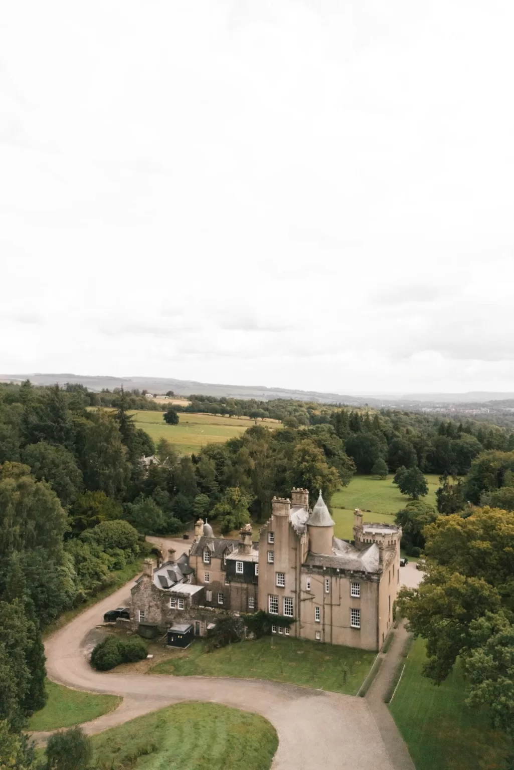 Elevated view of Boturich Castle estate set within rolling countryside near Loch Lomond.