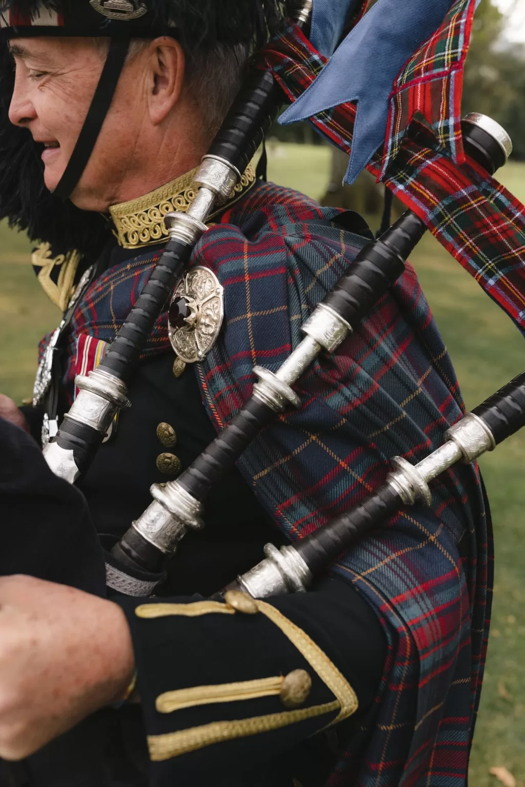 Close-up of traditional Scottish bagpipes worn by a musician during a wedding at Boturich Castle.