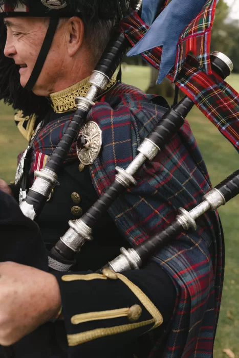 Close-up of traditional Scottish bagpipes worn by a musician during a wedding at Boturich Castle.
