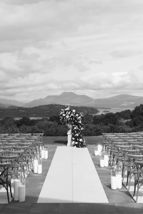 Outdoor wedding ceremony setup at Boturich Castle overlooking the loch and surrounding hills.