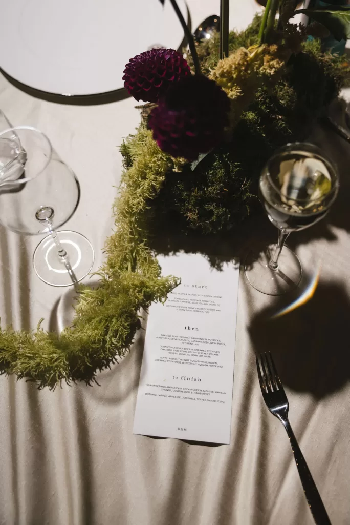 Wedding table styling with moss, florals and printed menus at Boturich Castle.