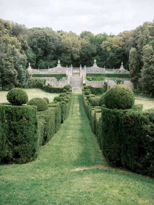 Symmetrical hedge-lined gardens leading to a grand stone staircase at Castello di Celsa.