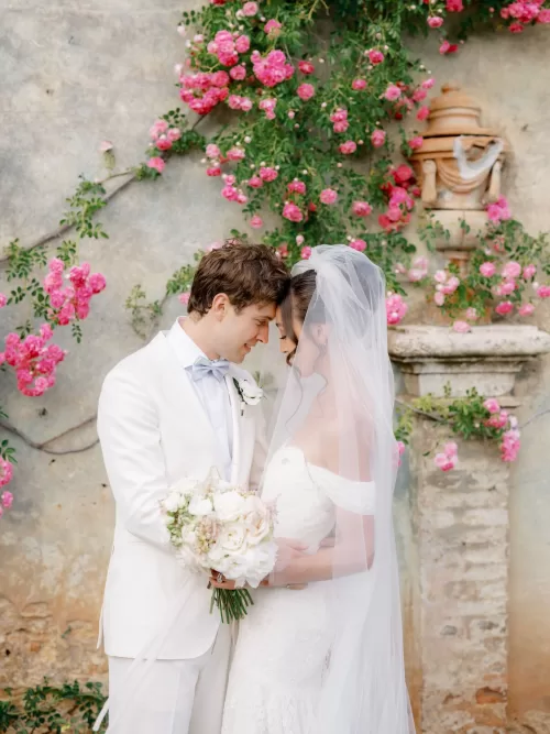 Romantic bridal portrait beneath blooming roses at Castello di Celsa with soft Tuscan light.