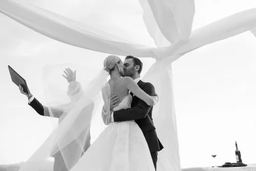 Newlyweds sharing a kiss beneath flowing ceremony drapery at Castello di Velona.