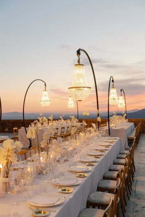 Elegant outdoor reception tables styled with white florals and chandeliers at Castello di Velona.