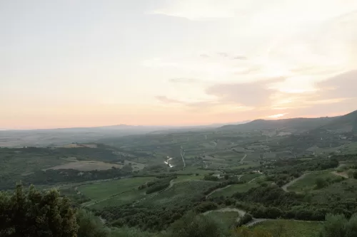 Panoramic Tuscan countryside views surrounding Castello di Velona at sunset.