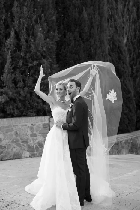Bride and groom reacting joyfully as the veil lifts during portraits at Castello di Velona.
