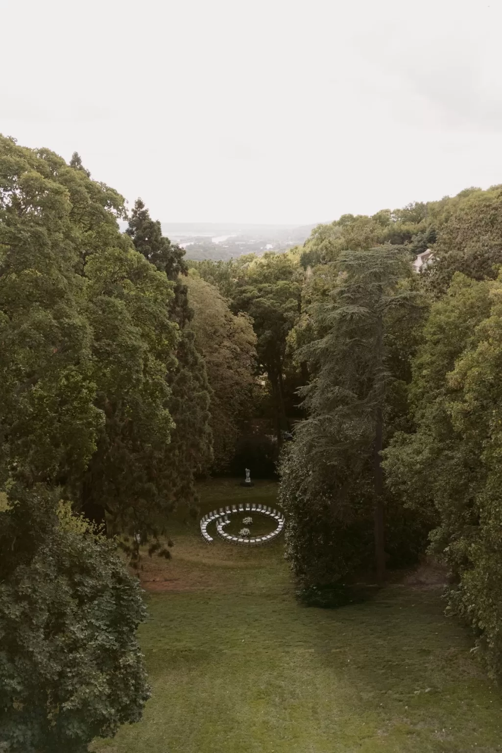 Circular outdoor ceremony setup nestled among trees at Château du Prieuré d’Evecquemont.