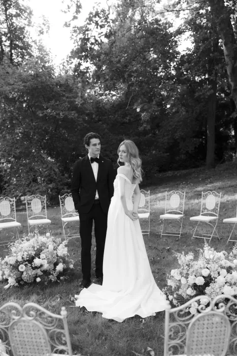 Bride and groom standing together in the garden ceremony space at Château du Prieuré d’Evecquemont, surrounded by chairs and florals.