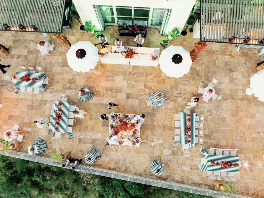 Overhead view of an evening wedding reception with long tables and cocktails at Domaine de Canaille