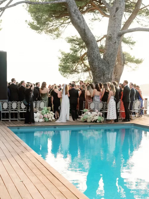 Bride and groom walking together beside the pool during a waterfront ceremony at Domaine de Canaille