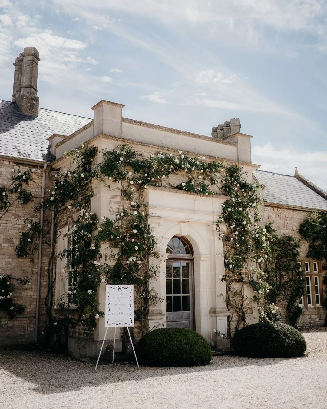 The elegant stone walls of Euridge Manor draped in wisteria, adding to its romantic ambiance.