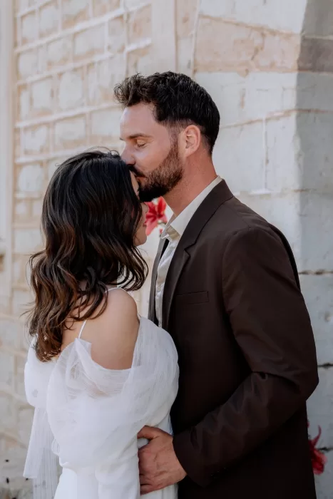 Newlyweds embracing against the stone walls of Finca Morneta, capturing an intimate moment after the ceremony.