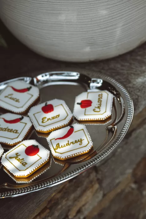 Personalised wedding cookies with red pepper and tomato motifs displayed on silver tray at Hotel Ristorante La Darsena.