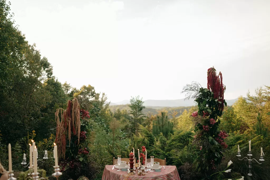 Guests seated for dinner at House Boheme with panoramic mountain views beyond the terrace, capturing a relaxed al fresco celebration.