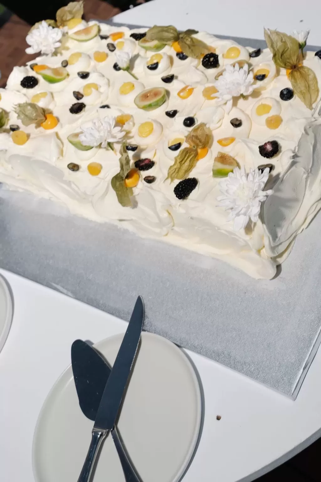 Rectangular wedding cake topped with fresh fruit and flowers at Minthis Resort.