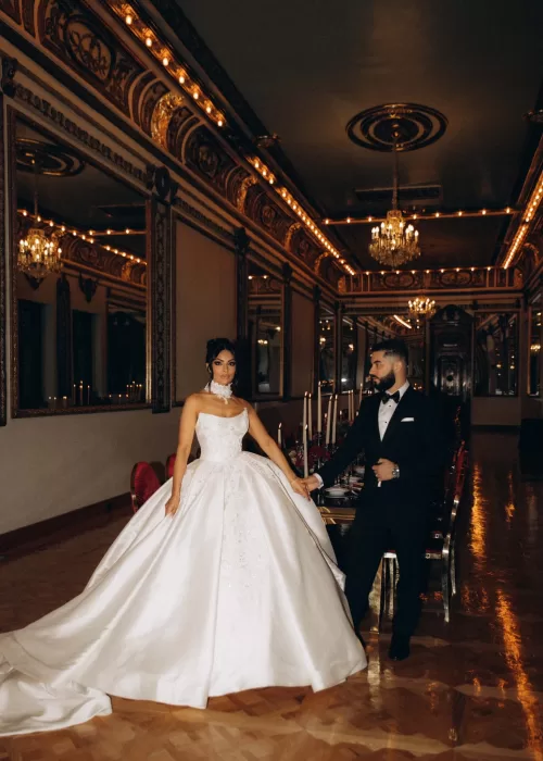Bride and groom walking hand in hand through the mirrored ballroom at Palacio Metropolitano, candlelight reflecting across parquet floors.