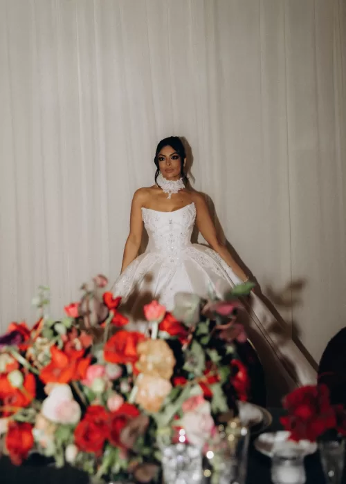 Bride posing against soft drapery inside Palacio Metropolitano, her structured satin gown and lace neckline highlighted by dramatic light.