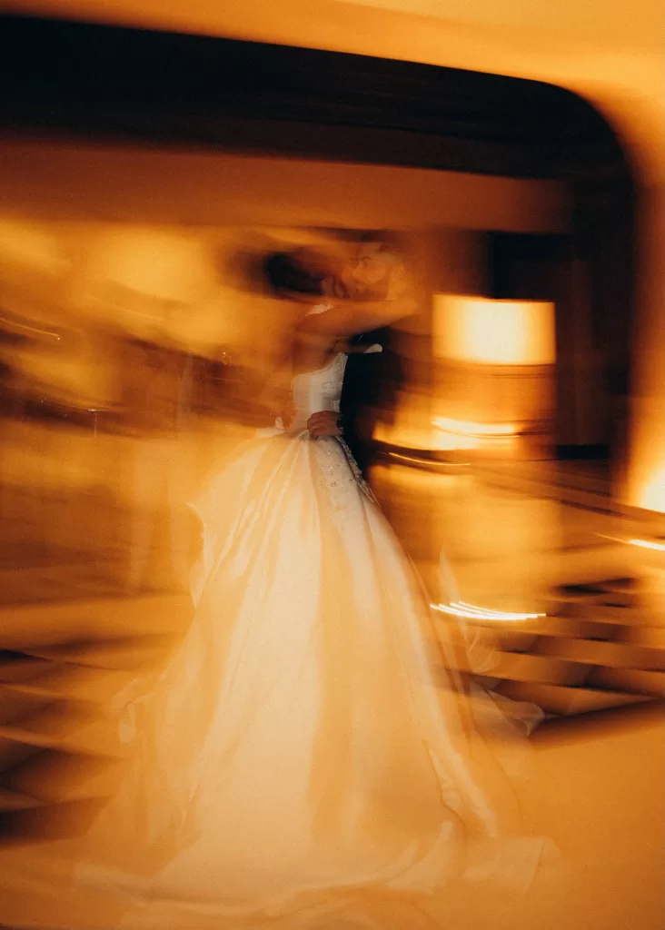 Bride and groom sharing a romantic first dance at Palacio Metropolitano, captured in warm golden motion blur.