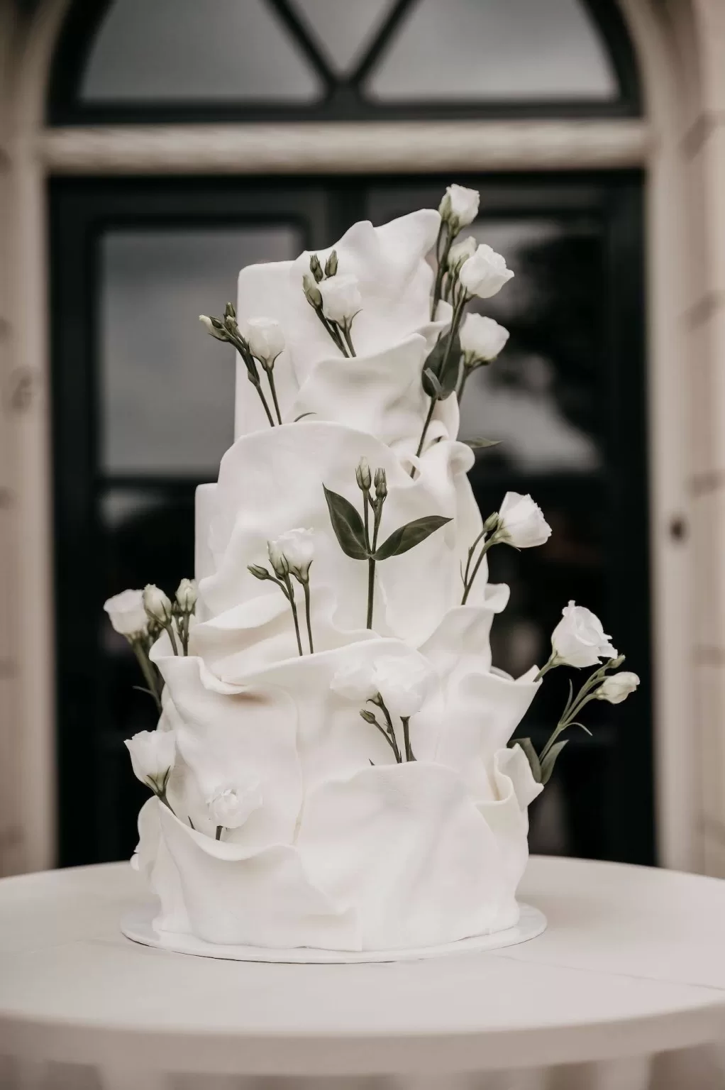 Modern white wedding cake decorated with delicate flowers at Parc Broekhuizen.
