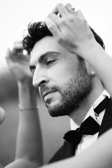 Black and white close-up of groom adjusting his hair before his Villa Honegg wedding ceremony.