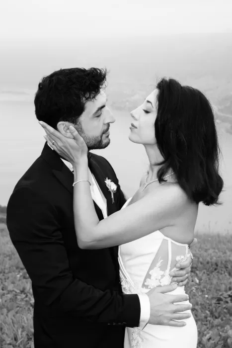 Black and white portrait of bride and groom embracing on a hillside overlooking Lake Lucerne at Villa Honegg.