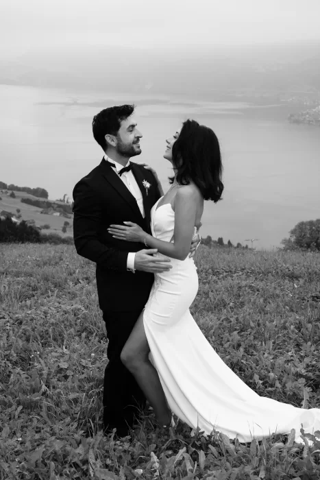 Bride and groom embracing on a hillside above Lake Lucerne during their Villa Honegg destination wedding.