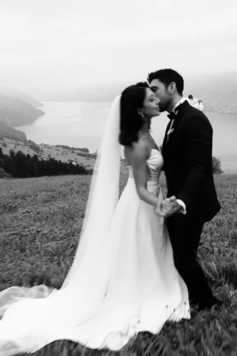 Black and white portrait of bride and groom holding hands on a hillside above Lake Lucerne near Villa Honegg.