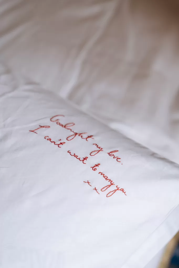 Close-up of embroidered love note stitched in red on fabric, intimate wedding detail at Castello di San Fabiano