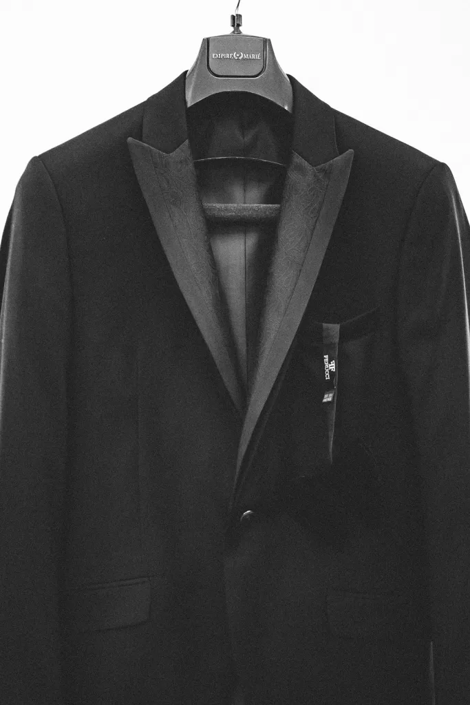 Classic black tuxedo jacket hanging neatly before the wedding at Château Bouffémont.