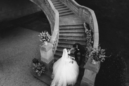 Black and white overhead portrait of bride and groom sharing a moment on the curved staircase at Château Bouffémont.