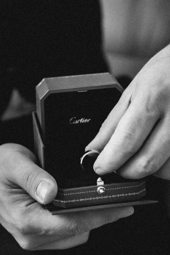 Close-up of wedding rings in a Cartier box held in hand during preparations at Château Bouffémont.