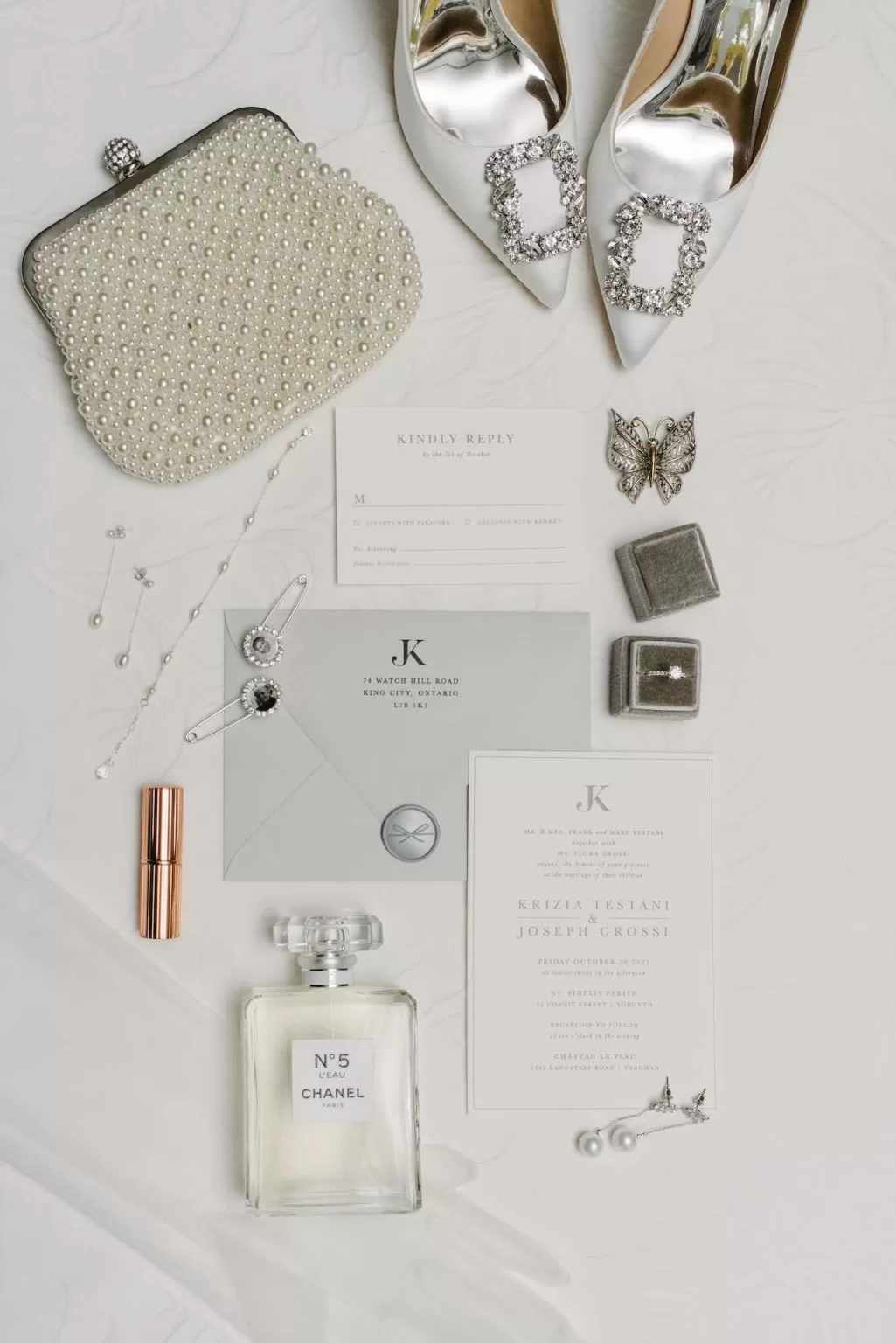 Elegant flat lay of wedding accessories, invitations, and Chanel perfume for a celebration at Château Le Parc.
