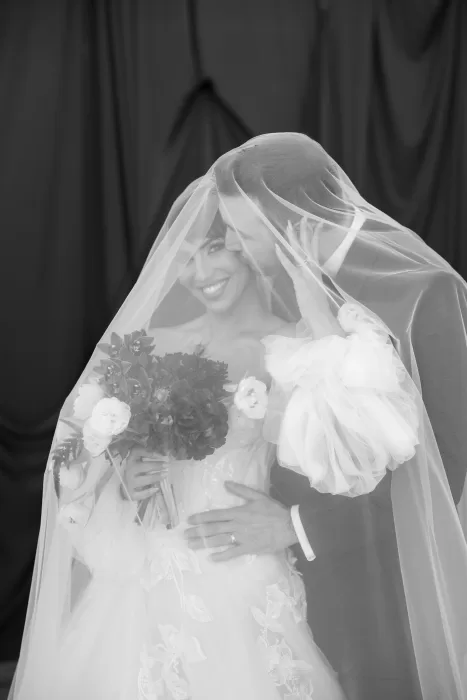 Black and white portrait of the bride and groom beneath a veil, sharing an intimate moment during their Common Goods wedding.
