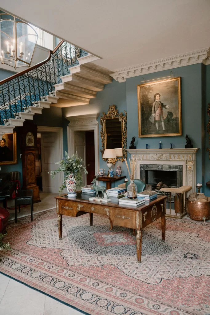 Elegant lounge room at Hotham Hall Estate with antique furniture, fireplace and decorative details
